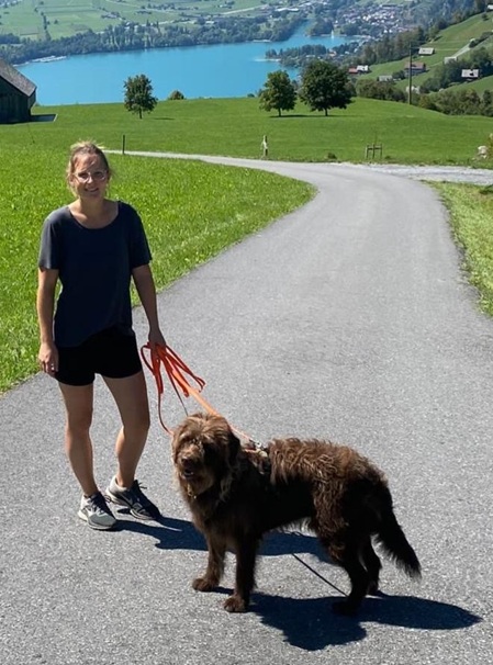 Frau mit Hund auf einem Spazierweg