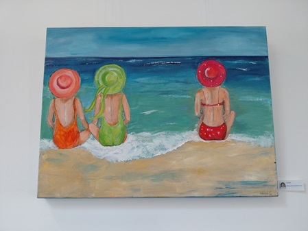 Drei Damen sitzen auf dem Strand und schauen ins Meer