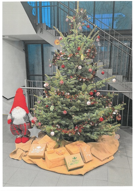 Schön geschmückter Weihnachtsbaum mit Wichtel und Geschenkpäckchen